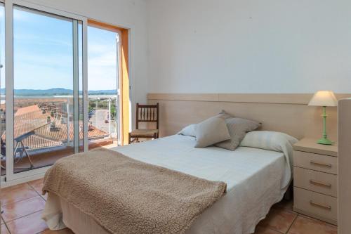 een slaapkamer met een bed en een groot raam bij Àtic Brisa Mar in L'Estartit