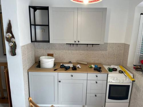 a kitchen with white cabinets and a counter top at Apartment 'Dan' in Zlarin