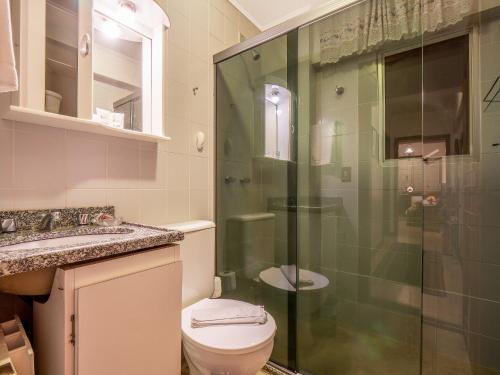 y baño con aseo y ducha acristalada. en Planalto Verde - 104, en Gramado