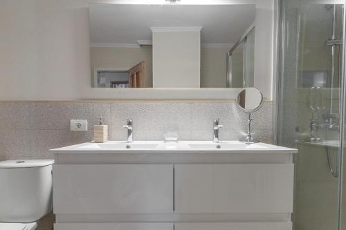 a bathroom with a white sink and a mirror at Casa Juanita in Playa de San Juan