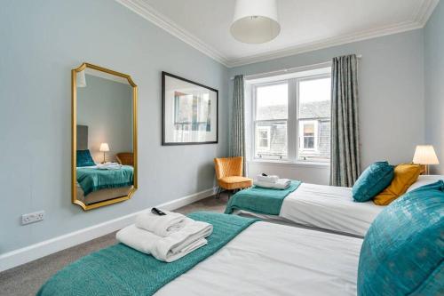een hotelkamer met 2 bedden en een spiegel bij 10 Murray Park in St Andrews