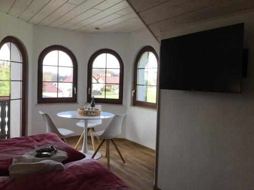 a bedroom with a bed and a table and windows at Ferienhaus Barth in Bad Salzungen
