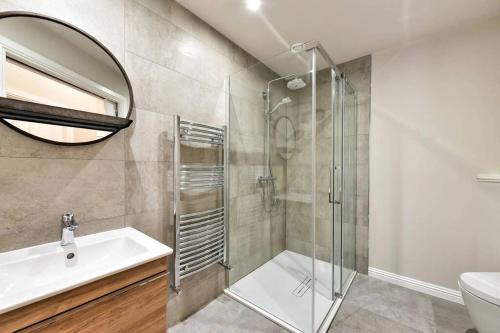 a bathroom with a shower and a sink and a mirror at 24a Murray Park in St. Andrews
