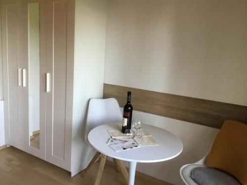 a white table with a bottle of wine and a glass at Ferienhaus Barth in Bad Salzungen