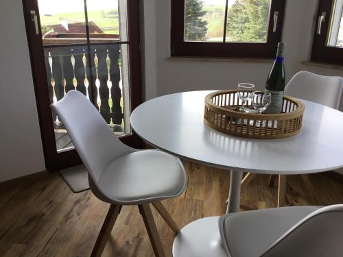 a white table and chairs with a wine bottle on it at Ferienhaus Barth in Bad Salzungen