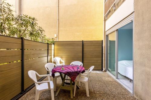 - un balcon avec une table et des chaises dans l'établissement Appartement Undi - Welkeys, à Bandol