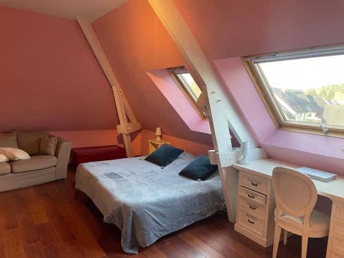 1 Schlafzimmer mit einem Bett, einem Schreibtisch und 2 Fenstern in der Unterkunft Maison Proche de Le Mans Classique in Changé