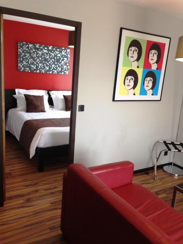 a bedroom with a bed and a red couch at Best Western Park Hotel Geneve-Thoiry in Thoiry