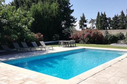 - une piscine avec des chaises et une table dans la cour dans l'établissement Mas de la Digue, Châteaurenard, 6 chambres, 5 sdb., à Châteaurenard
