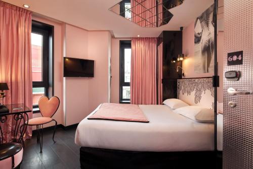 a hotel room with a bed and a table and a chair at Vice Versa in Paris