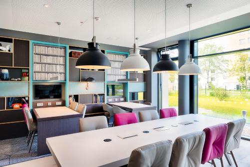 a dining room with a large white table and chairs at Premier Inn Berlin Airport in Berlin