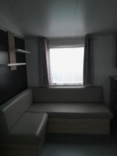 um pequeno quarto com uma janela e um sofá em Les Résidences La becque em Warhem