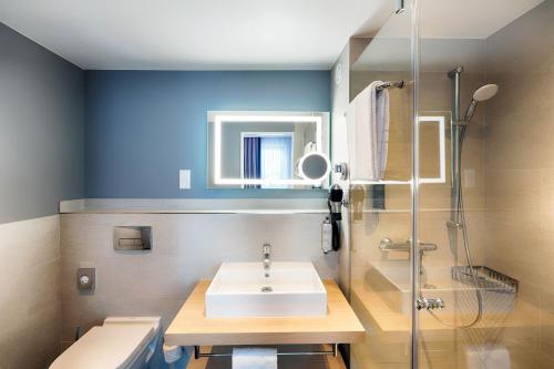 a bathroom with a sink and a shower at Premier Inn Berlin Airport in Berlin