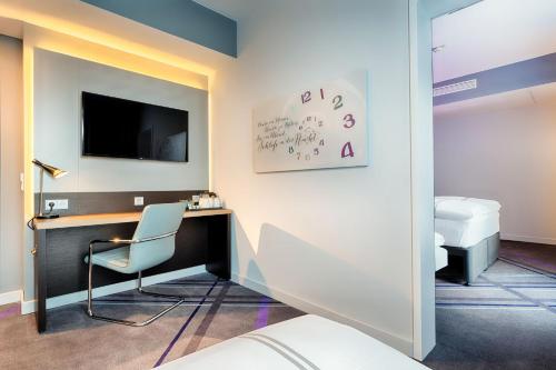 a room with a desk with a tv and a chair at Premier Inn Berlin Airport in Berlin