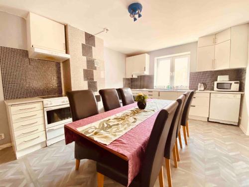 uma cozinha com uma mesa com cadeiras e uma sala de jantar em Bjurviks Villa - Flat 2 em Flen
