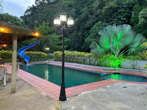 un poste de luz junto a una piscina con tobogán en Hotel Los Mangos, en San Luis