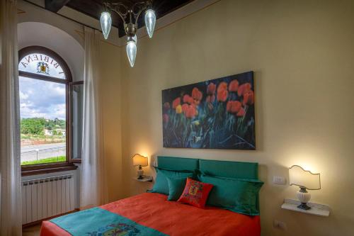 1 dormitorio con 1 cama con una pintura en la pared en IBibiena - CASA CAMPALDINO, en Poppi