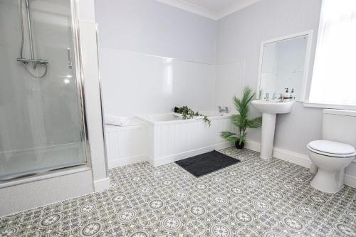 a white bathroom with a toilet and a sink at Stylish, spacious 3 bed house. Sleeps 7 in Lincoln