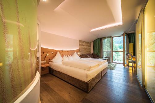 ein Schlafzimmer mit einem großen Bett in einem Zimmer in der Unterkunft Hotel Krallerhof in Leogang