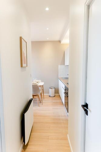 Il comprend une cuisine et une salle à manger avec des murs blancs et du parquet. dans l'établissement Le provençal - Beau T2 centre ville - Gare - Tram, au Mans