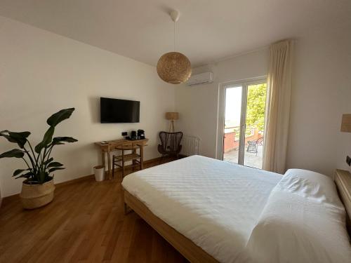1 dormitorio con cama blanca y ventana en Vistalago, en San Lorenzo Nuovo