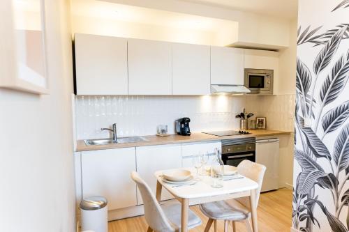 a small kitchen with a white table and chairs at Le provençal - Beau T2 centre ville - Gare - Tram in Le Mans