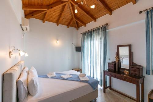 a bedroom with a bed and a mirror and a table at Voula Resort in Elafonisos