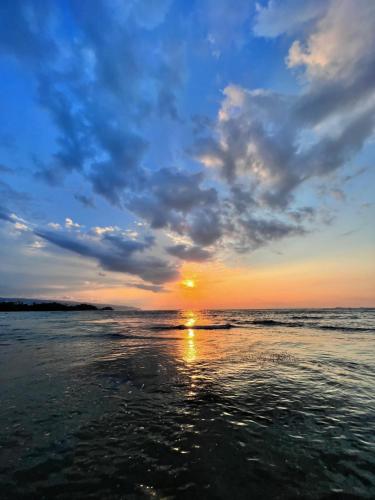 a sunset on a beach with the ocean at Hotel La Tortuga in Las Terrenas