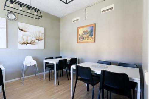 a dining room with tables and chairs and a clock at Nicolai B&B in Lidköping