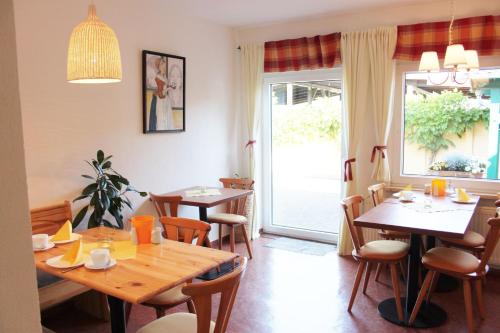 a dining room with tables and chairs and a window at Pension An der Kamske, FZ 5 Familien in Lübbenau