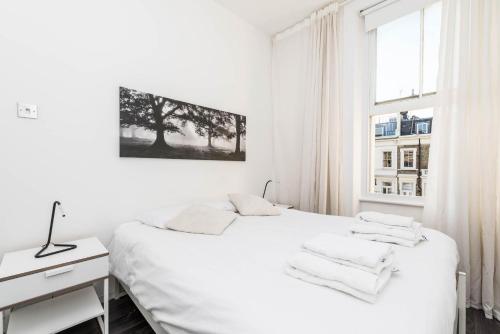 um quarto branco com uma cama e uma janela em Fantastic 1BD flat in the centre em Londres