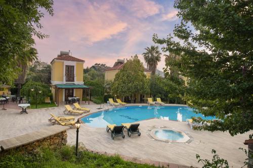 una piscina con sillas y una casa en Villa Alisa en Fethiye