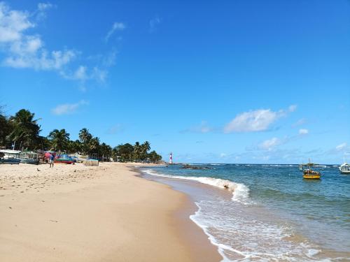 a sandy beach with boats in the water at Pousada Betel - Moradas Familia Betel in Salvador