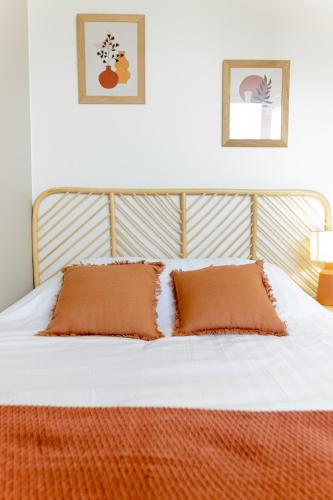 - un lit avec 2 oreillers orange dans l'établissement Le provençal - Beau T2 centre ville - Gare - Tram, au Mans