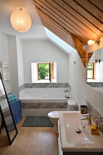 une salle de bain avec un lavabo et une baignoire dans l'établissement LES CHAMBRES AUX LOUPS en Brocéliande, à Iffendic