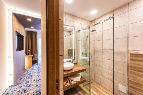 a bathroom with a shower and a sink at Hotel Tusnad in Băile Tuşnad