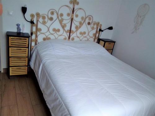 a bedroom with a white bed with a gold headboard at T3 Duplex 65 m2 6 lits 2 SDB terrasse clim garage in Valescure