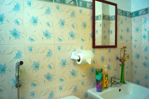 a bathroom with a sink and blue flowers on the wall at Madie's Place Guest House in Santa Rosa