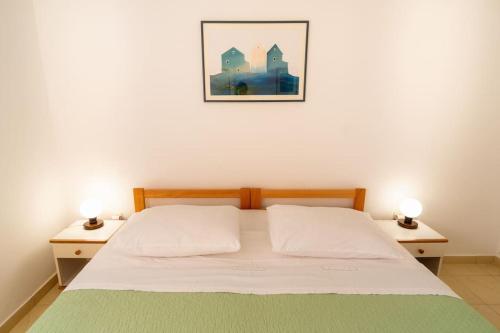ein Schlafzimmer mit einem Bett mit zwei Nachttischen in der Unterkunft Cozy 1 bedroom apt/terrace/garden in Bol