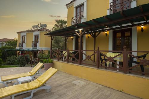 un patio con 2 tumbonas y una casa en Villa Alisa en Fethiye