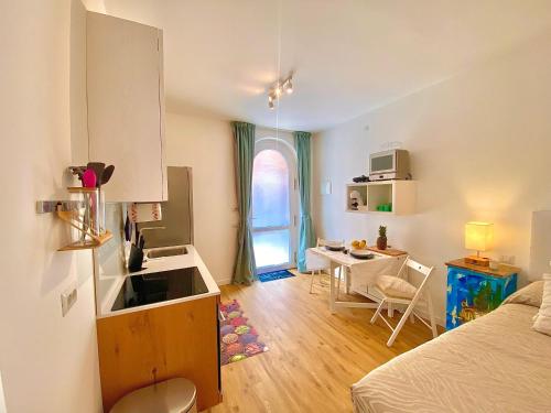 a room with a kitchen with a sink and a table at Appartamento Alice Smart in Bardolino