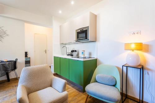 un salon avec une chaise et une cuisine dans l'établissement LE ROSSINI AP4228 By Riviera Holiday Homes, à Nice