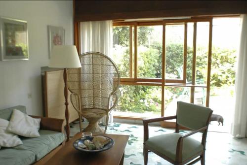 ein Wohnzimmer mit einem Sofa, einem Stuhl und einem Ventilator in der Unterkunft Villa Il Platano con giardino Beachfront in Forte dei Marmi