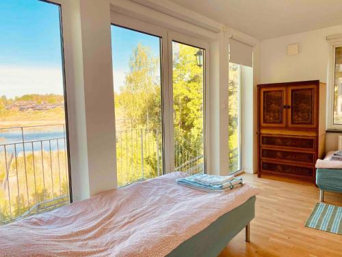- une chambre avec un lit et de grandes fenêtres dans l'établissement Bjurviks Villa - Flat 1, à Flen