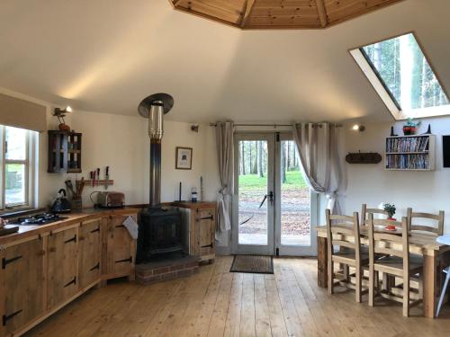 a kitchen with a stove and a table and chairs at Woodpecker Cabin with Hot tub in Kings Lynn