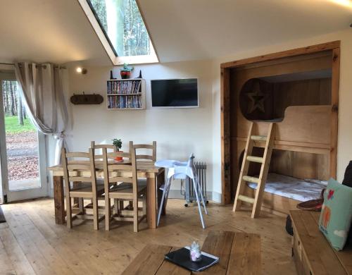 a living room with a table and chairs and a window at Woodpecker Cabin with Hot tub in Kings Lynn