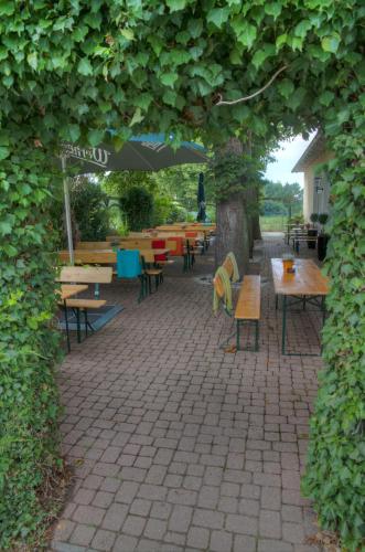 an outdoor patio with tables and chairs and an umbrella at Puppenstübchen in Wittenbeck