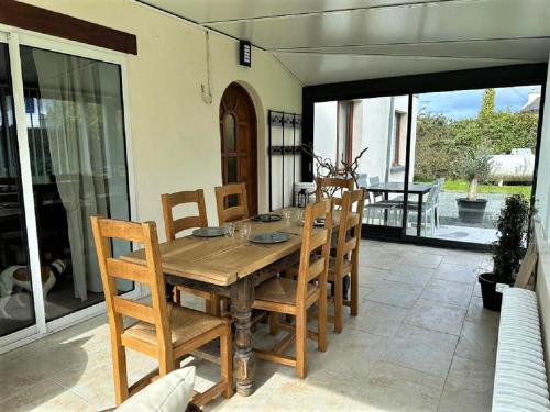 une table et des chaises en bois sur une terrasse dans l'établissement Longère bretonne à 700m de la mer et à proximité de Paimpol, à Plouézec