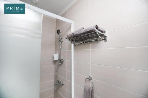 ein Bad mit einer Dusche und einem Handtuch an der Wand in der Unterkunft Prime Holidays Caesar Bay in Marsa Matruh