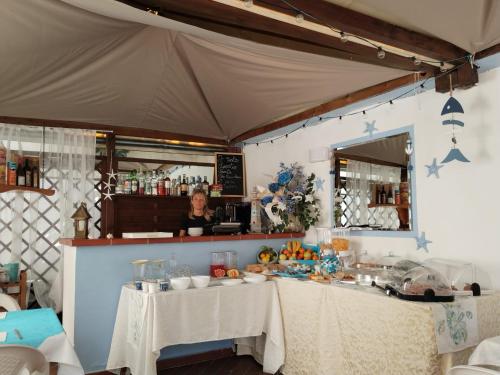 a woman standing behind a bar in a tent at Hotel Canarco in Viareggio